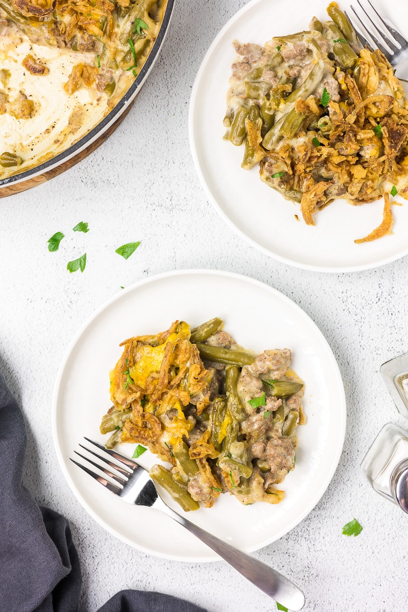 Green bean casserole on a white plate with a fork.