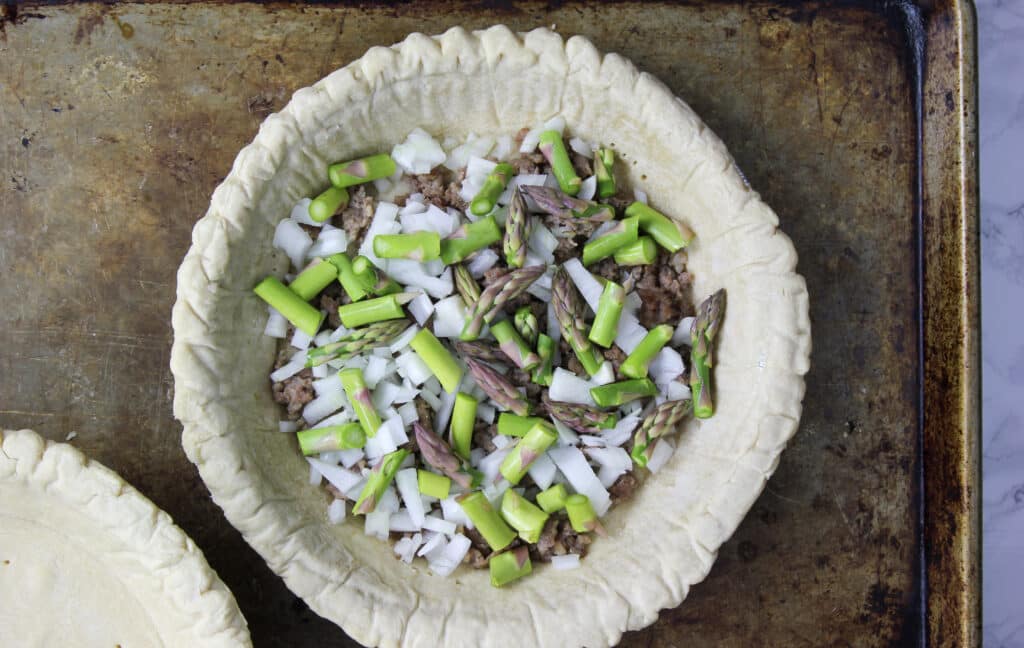 pie crust with sausage, onion and asparagus