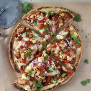 bbq chicken flatbread with pizza cutter on board