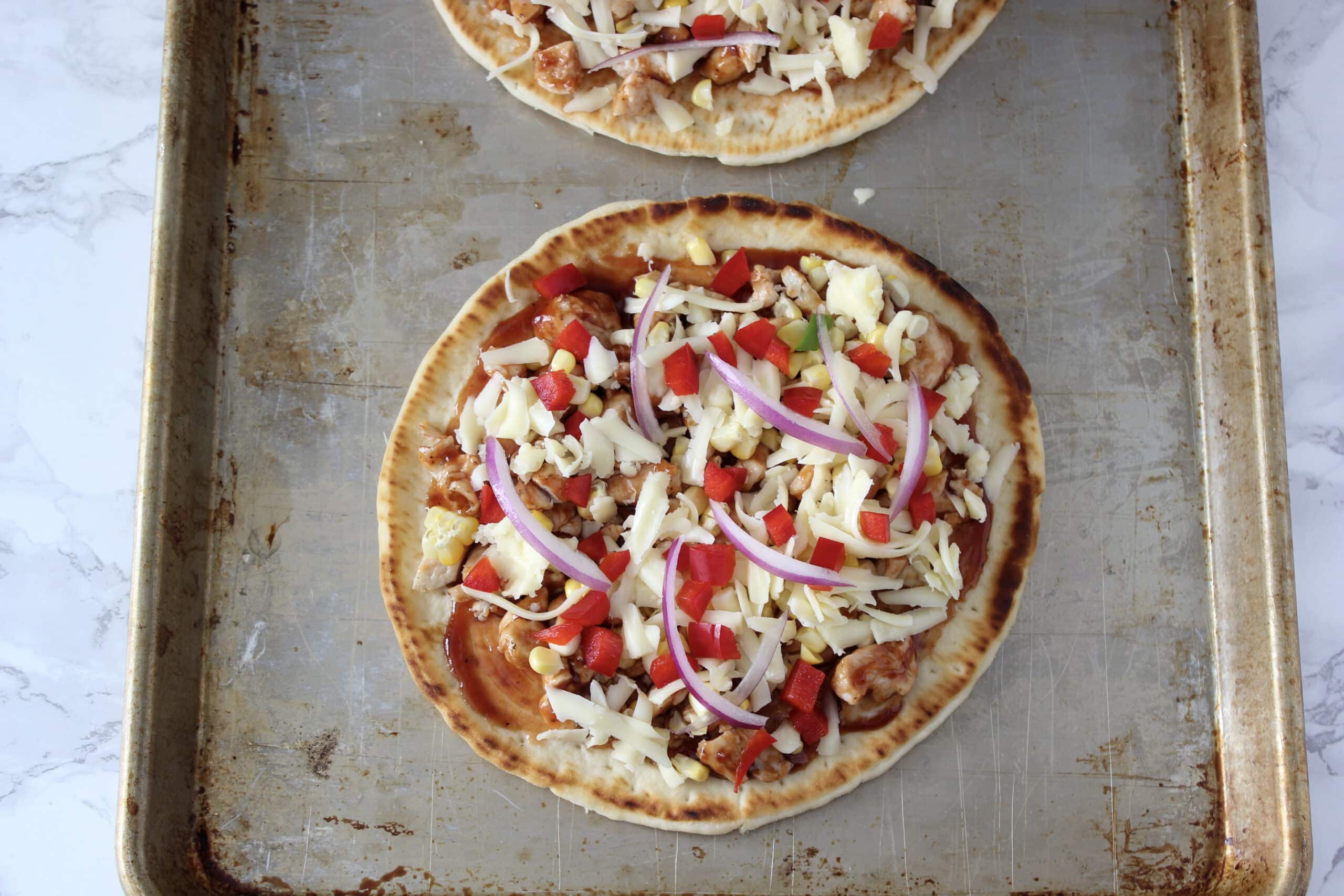 Flatbread before baking with toppings.