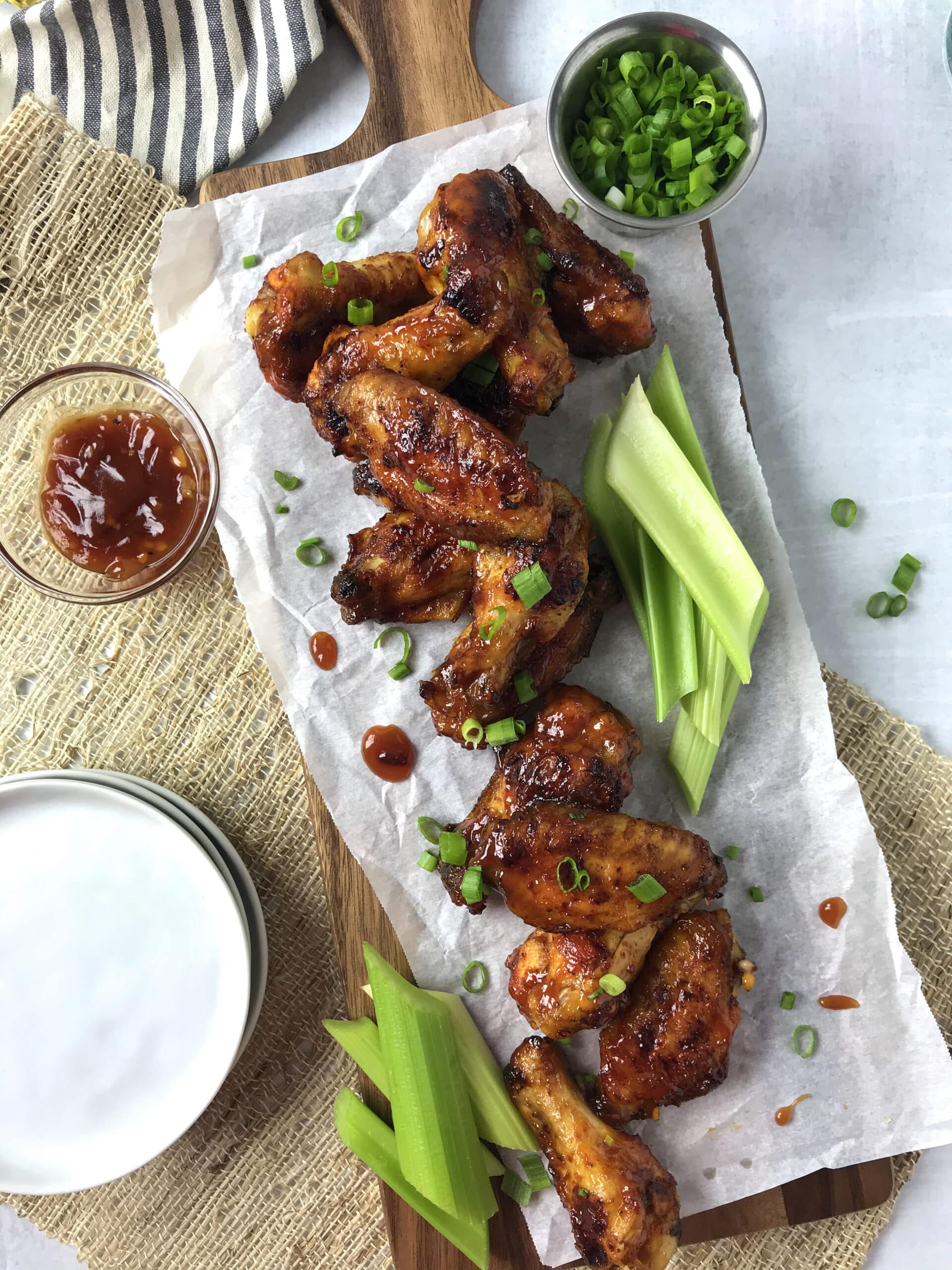 Chicken wings on a cutting board with celery.
