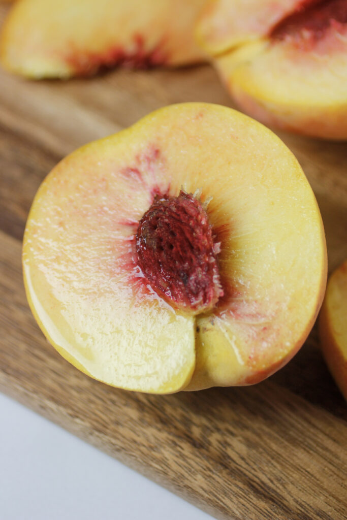 half of a fresh peach on cutting board
