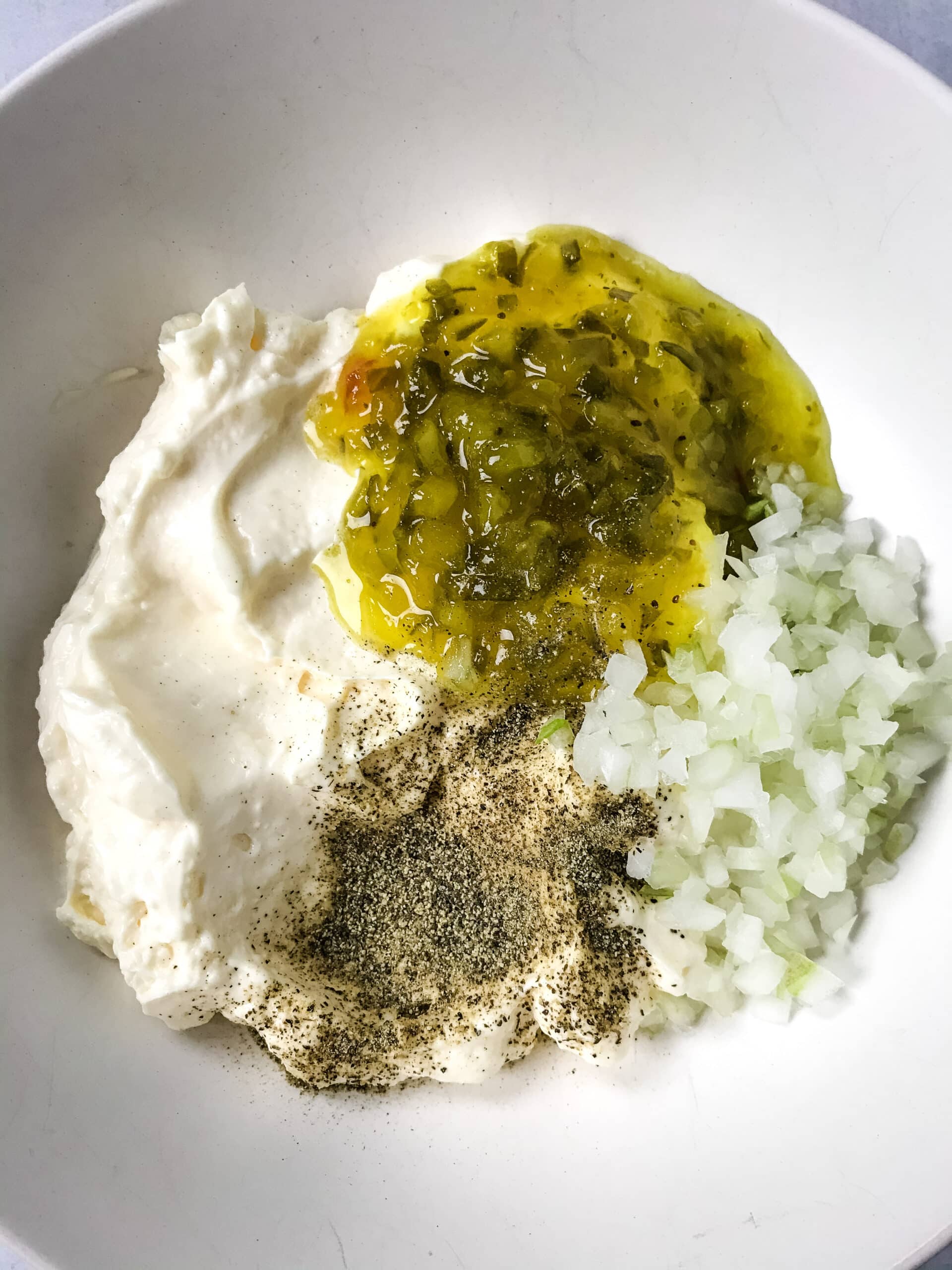 mayonnaise, sweet relish, pepper and diced white onion in bowl for tartar sauce
