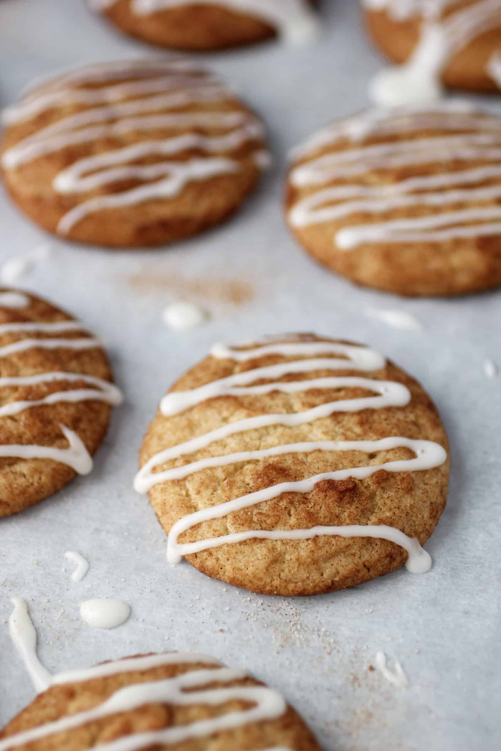 Chewy cinnamon cookies on cookie sheet with parchment paper.