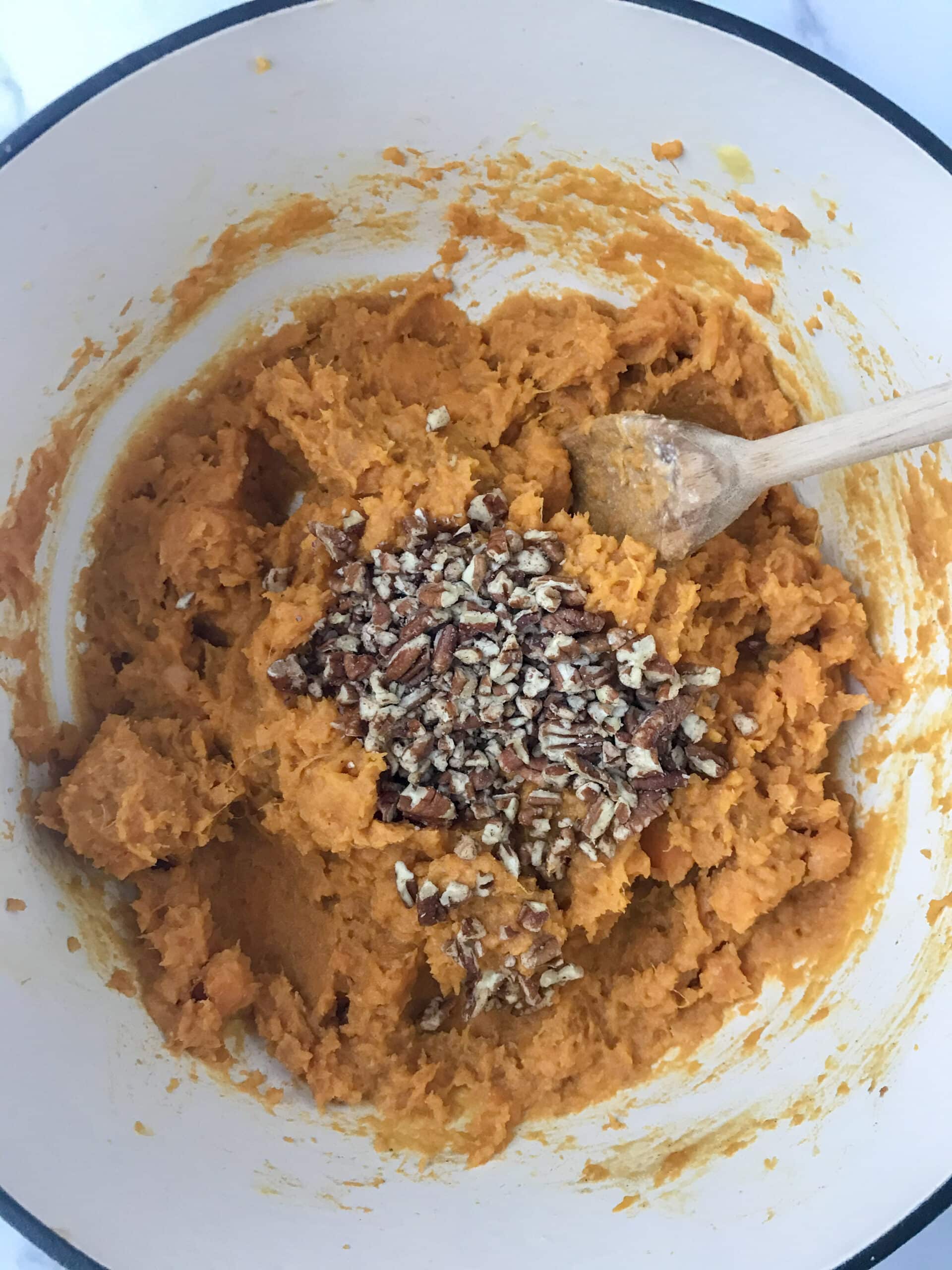 Sweet potatoes that have been mashed and pecans on top.