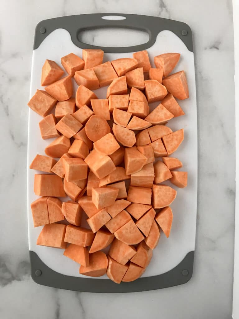 Chopped sweet potatoes on a cutting board.