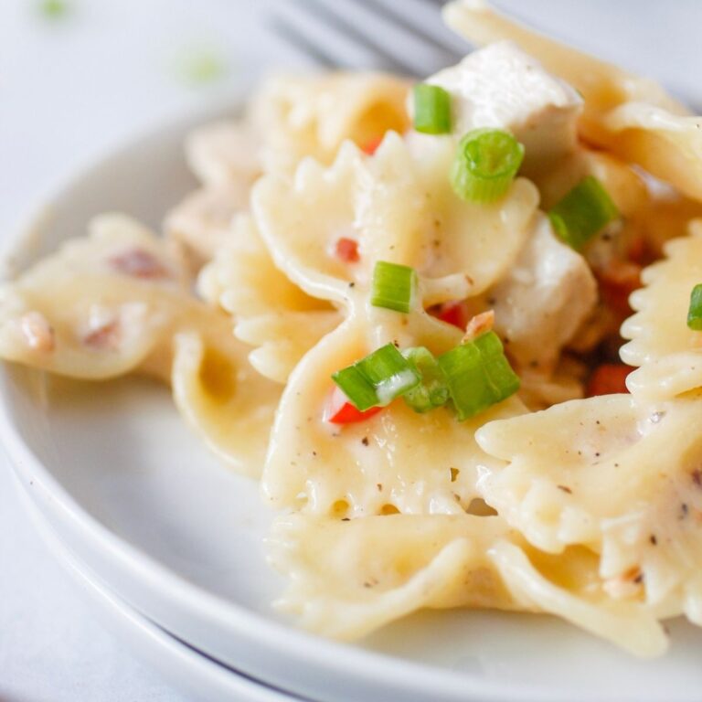 bow-tie pasta in a light cream sauce on two plates with fork