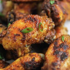 cajun wings that have been cooked with a cajun spice rub and are garnished with green onions