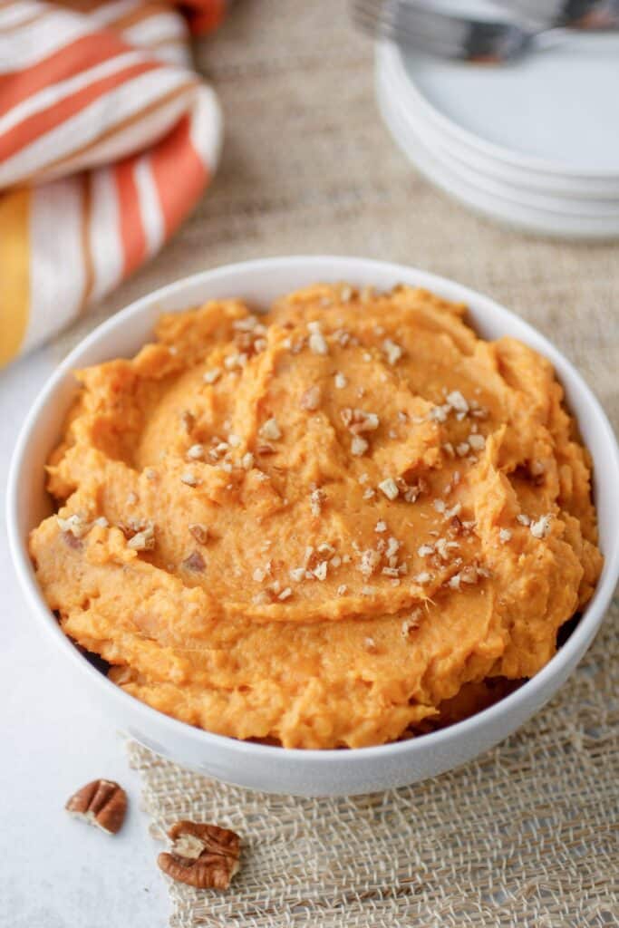 Mashed sweet potatoes in a white bowl.