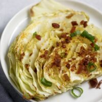 roasted cabbage on plate with acon and green onions