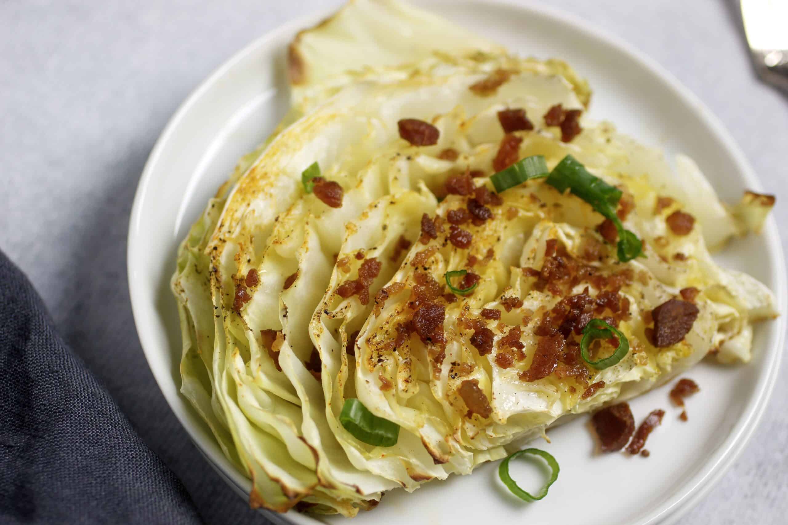 roasted cabbage on plate with acon and green onions