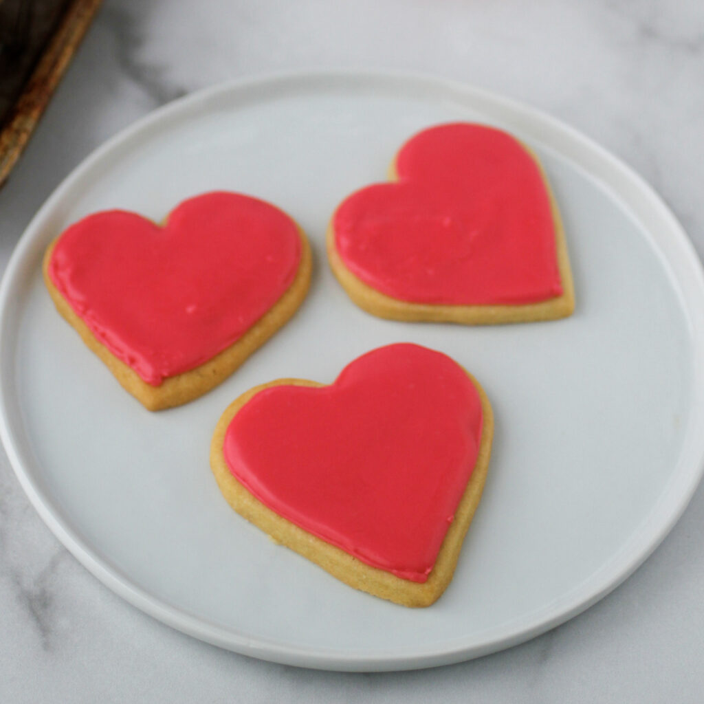 Easy Cut-Out Sugar Cookies on a plate with pink icing