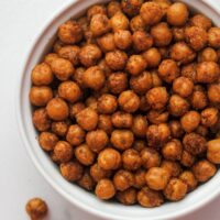 Spicey Roasted Chickpeas in a white bowl with a couple splilled out