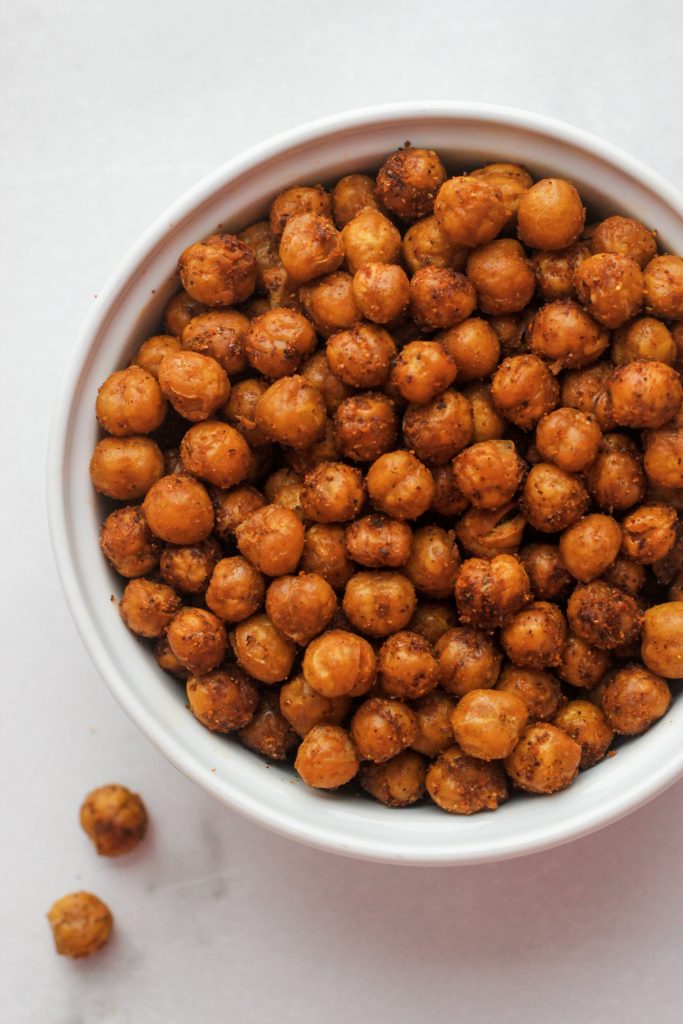 Spicey Roasted Chickpeas in a white bowl with a couple splilled out.
