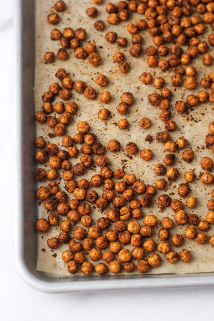 spicy roasted chickpeas after baking on baking sheet with parchment paper