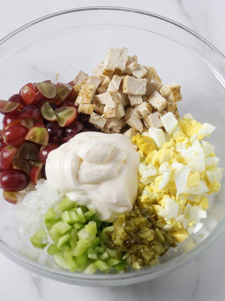 Chicken salad ingredients in a glass bowl.