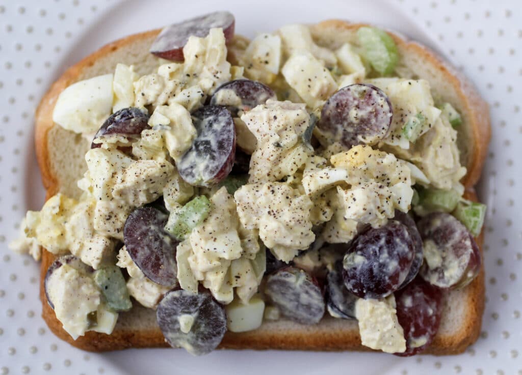 Classic Chicken salad on a piece of bread on top of a white plate.