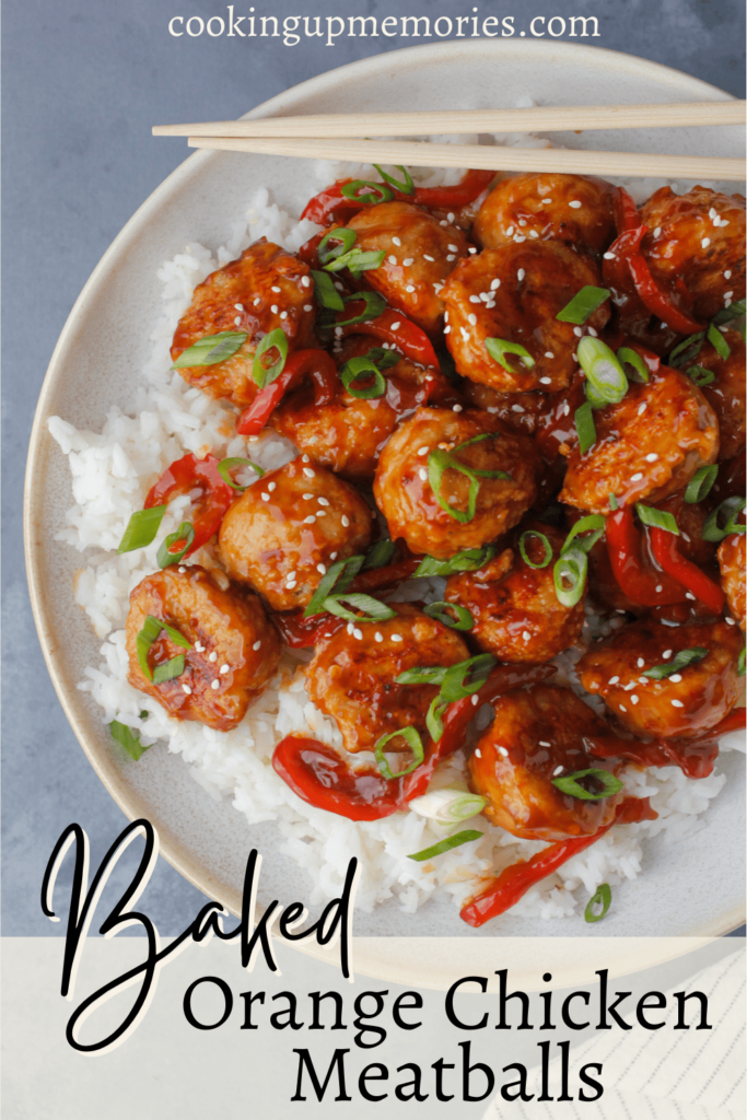 orange chicken meatballs over rice with green onions and toasted sesame seeds as garnish.
