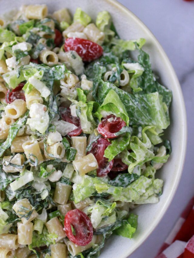 Caesar Pasta Salad with dressing in a white bowl.