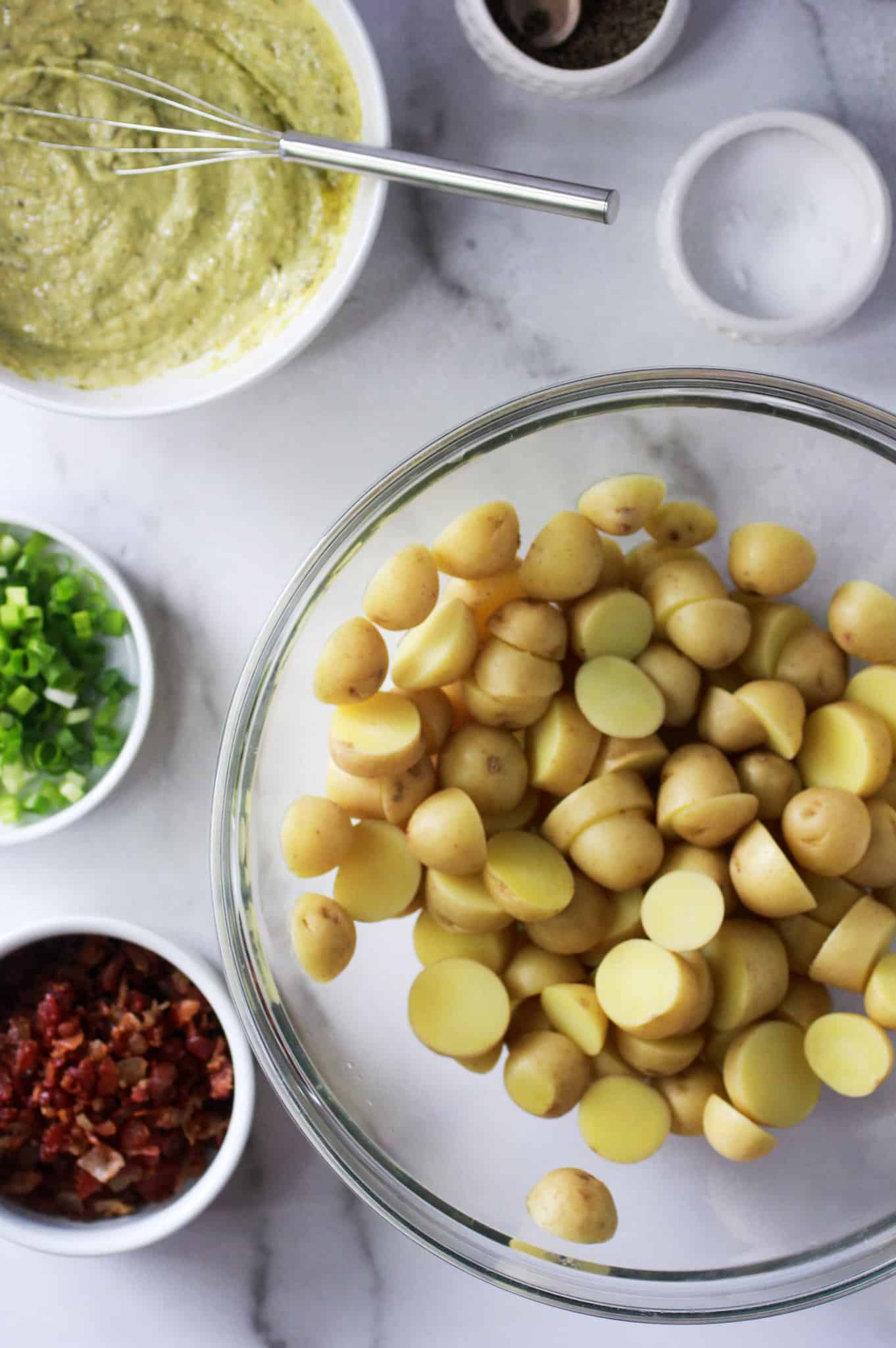 Bowl of cooked potatoes, dressing, bacon and green onions