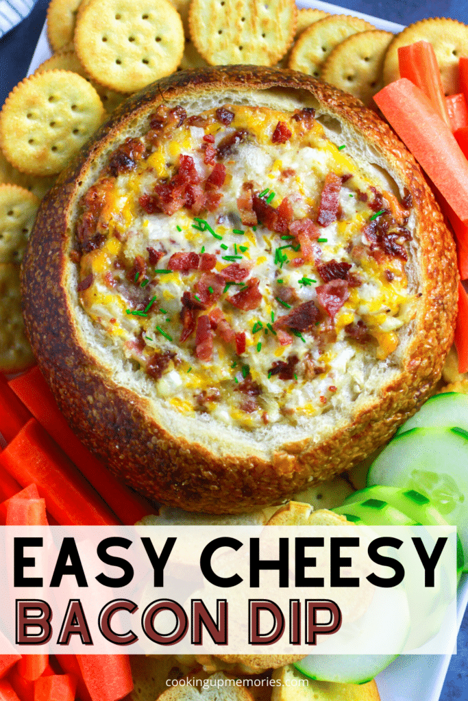 cheesy bacon dip in bread bowl served with crackers and vegetables.