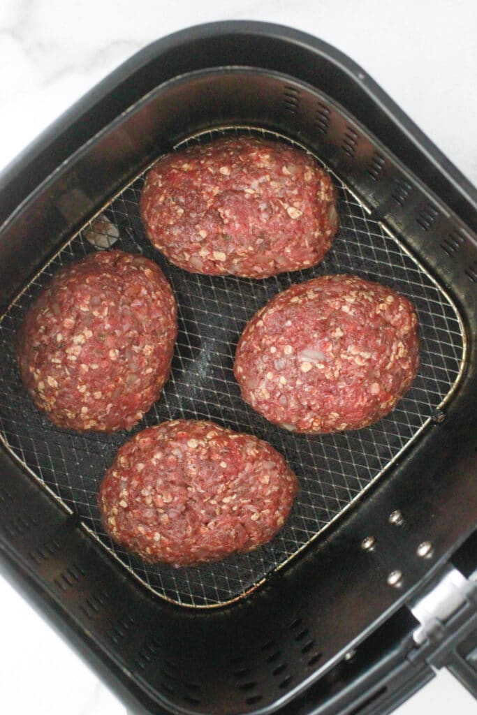 Air Fryer Meatloaf -Raw meatloaf in an air fryer basket.