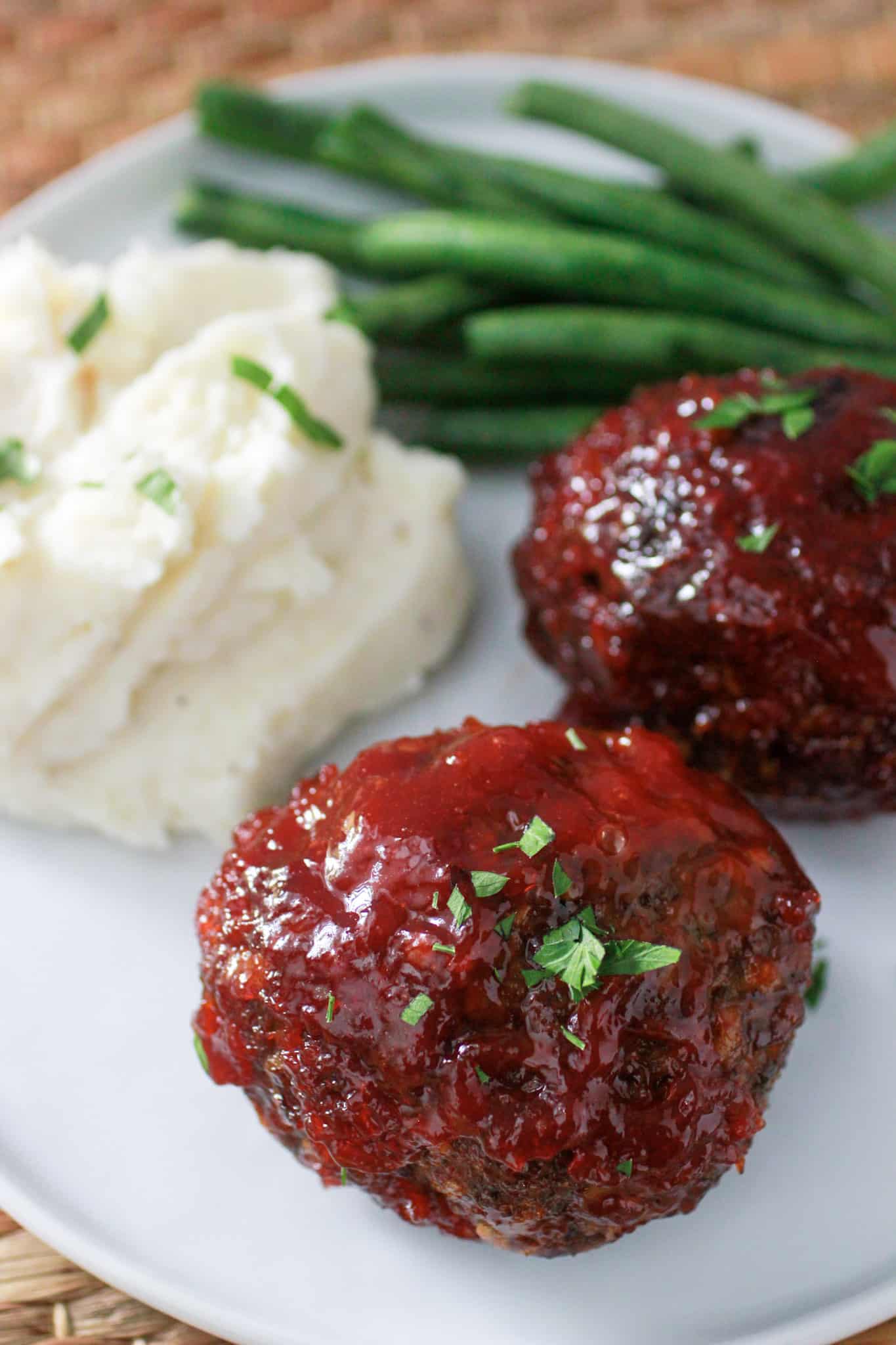 Air Fryer Meatloaf Recipe- Air Fryer Meatloaf on a white plate with green beans and mashed potatoes