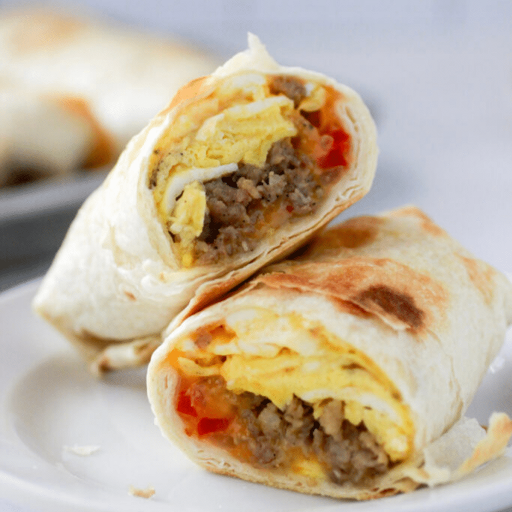 A sausage breakfast burrito cut in half.