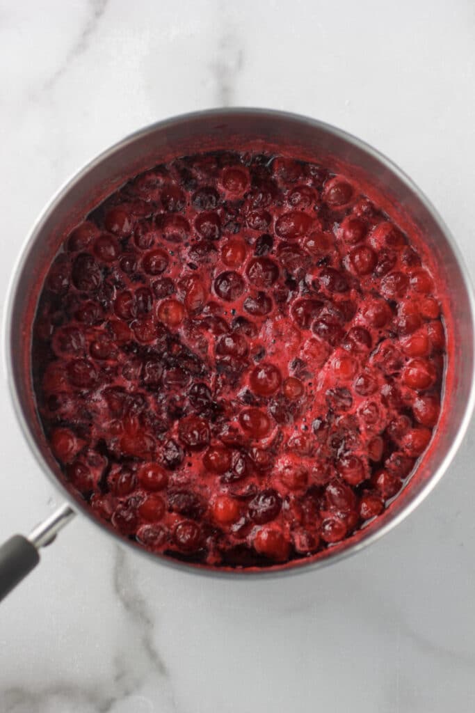 Cooked cranberries in a small sauce pan.