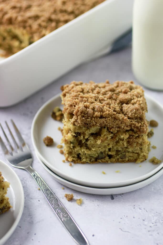 Apple Cinnamon Coffee Cake on a white plate with a fork and some milk.