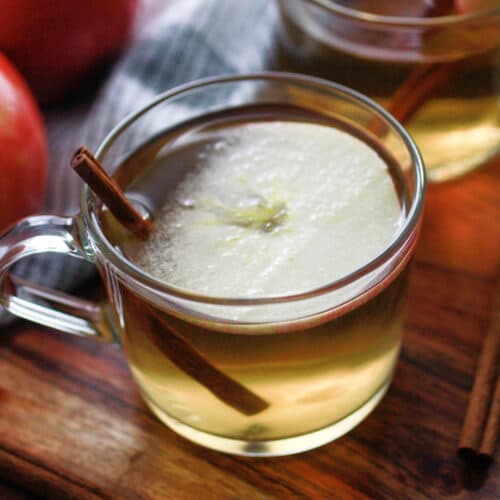 Apple hot toddy with a cinnamon stick and apple slice.