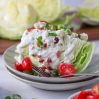Classic Wedge Salad on a plate with bacon and green onions.