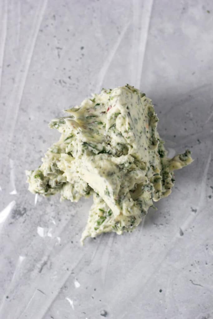 Herb Butter sitting on plastic wrap.