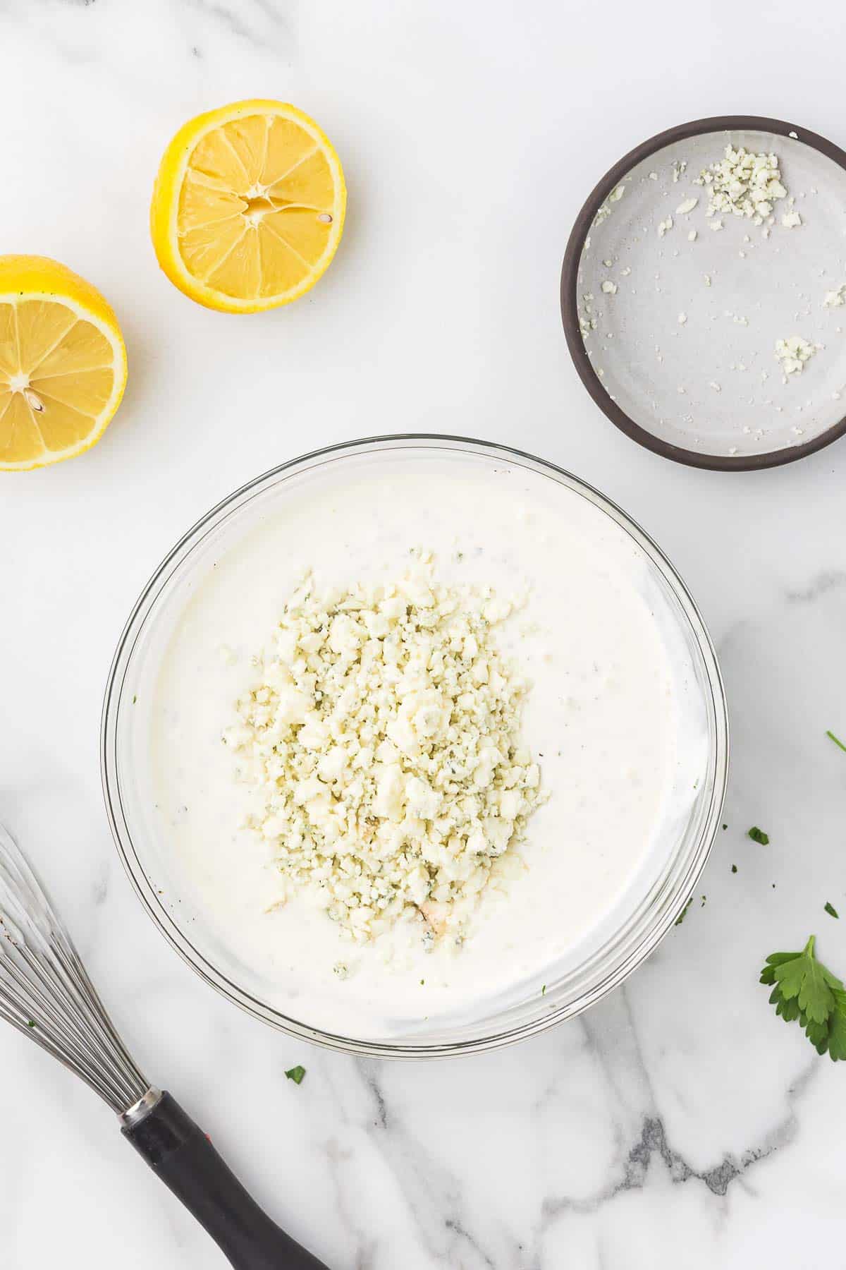 Blue cheese crumbles added to creamy dressing base while making steakhouse blue cheese dressing.
