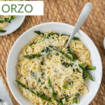 Asparagus Orzo in a white bowl with a serving spoon and pinterest text.
