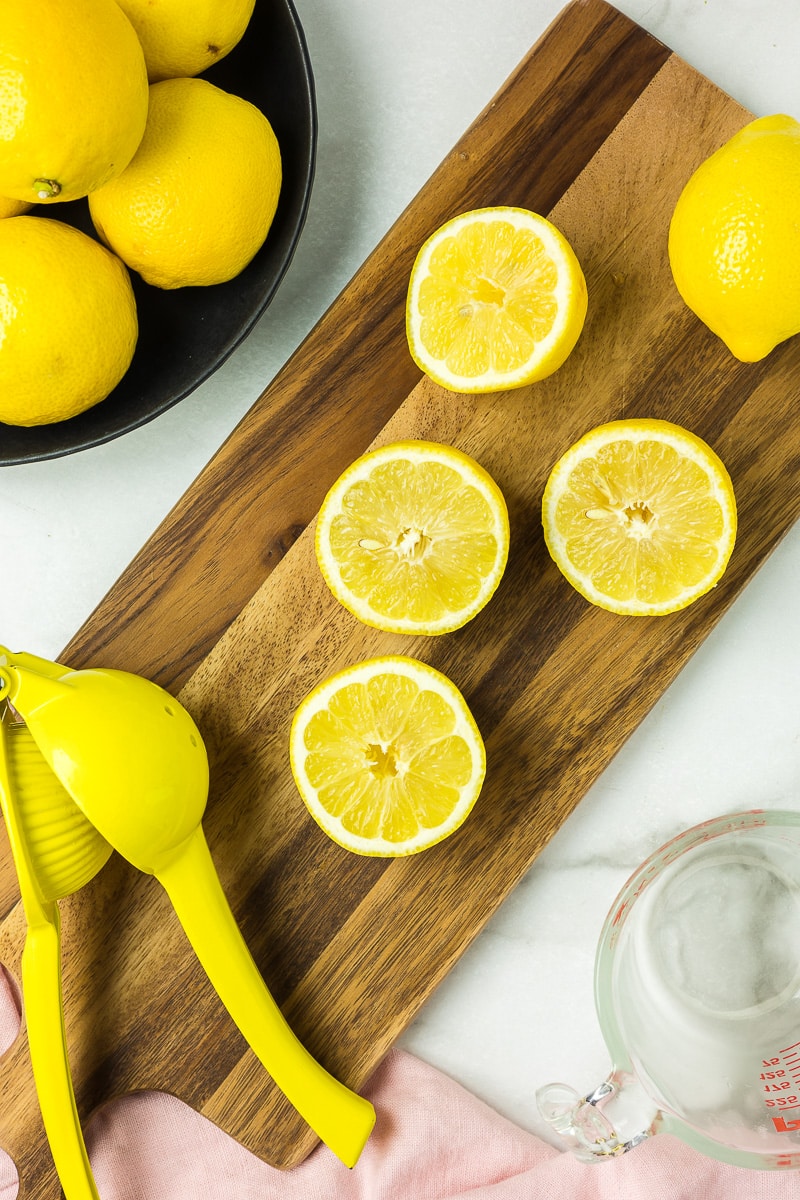 Lemons cut on a cutting board to make lemonade.