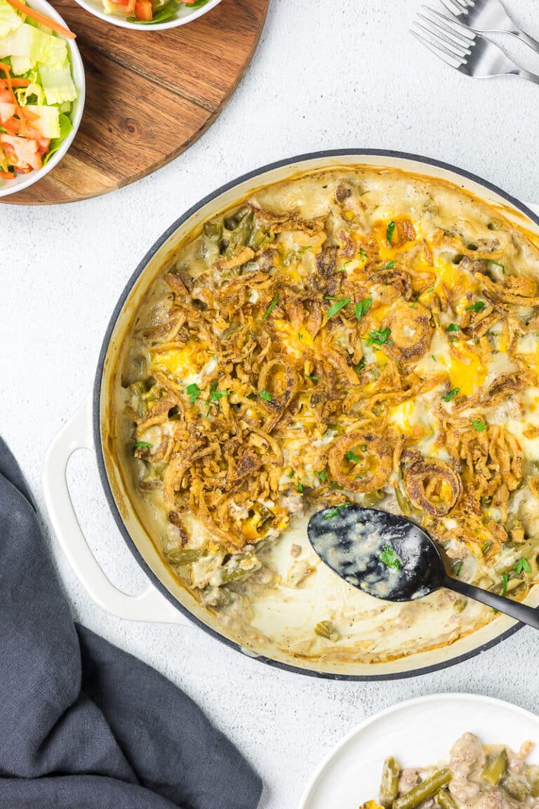 Green bean casserole in a dutch oven with a spoon.