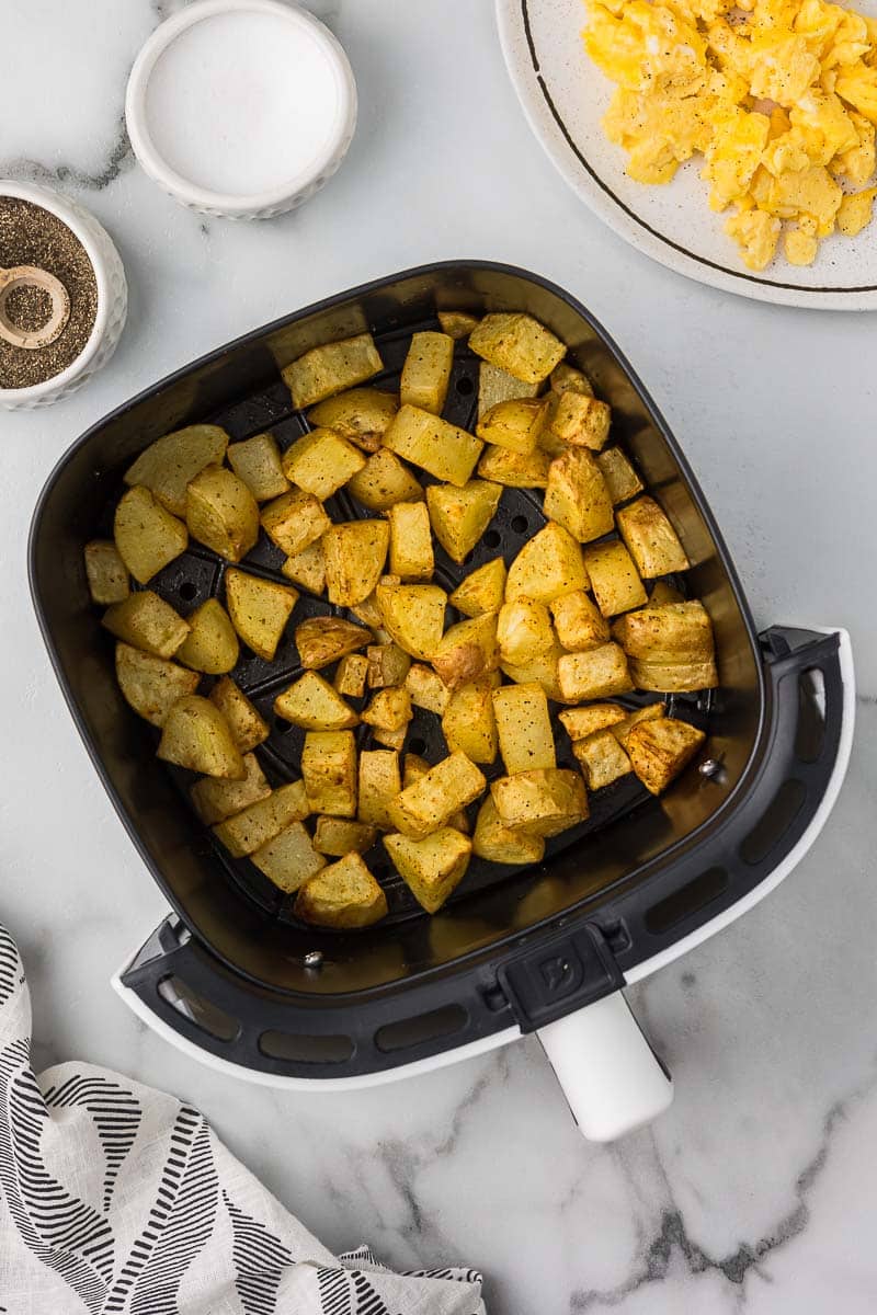 Air fryer breakfast potatoes in the basket of an air fryer.