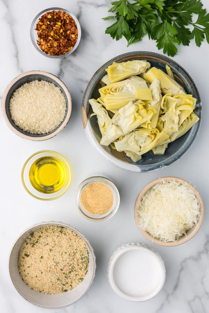 Air Fryer Artichoke Hearts ingredients in small bowls on a counter top.