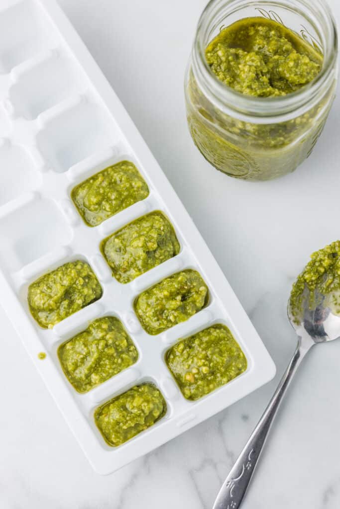 Leftover Pesto in a white ice cube tray for storage.