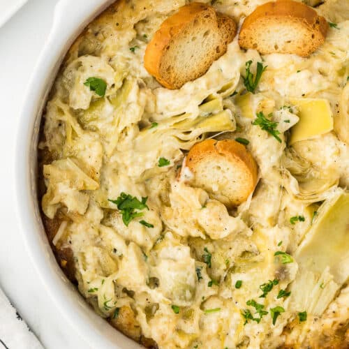 Hot Artichoke Dip in a white baking dish.