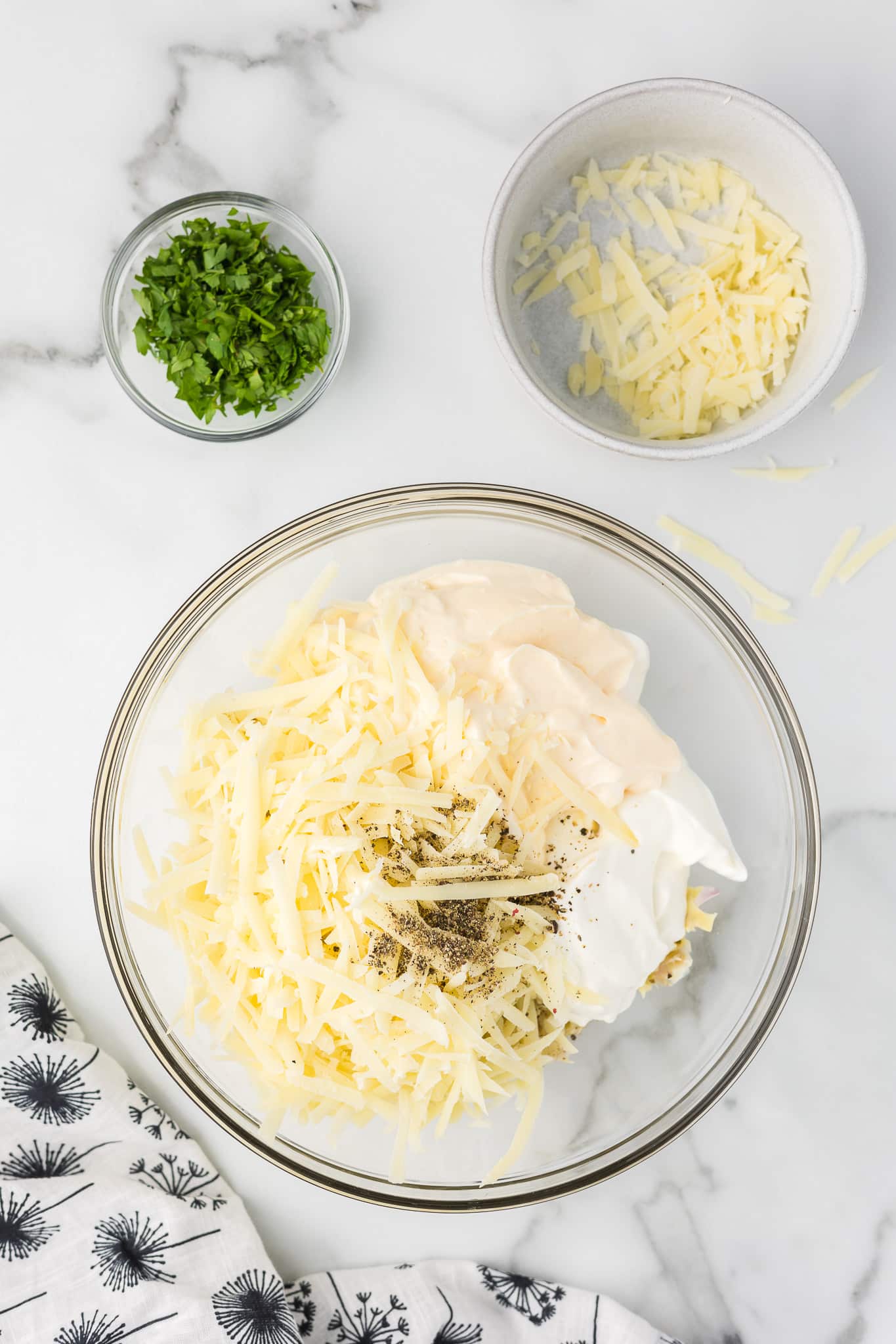 Mixing bowl with ingredients to make hot artichoke dip.