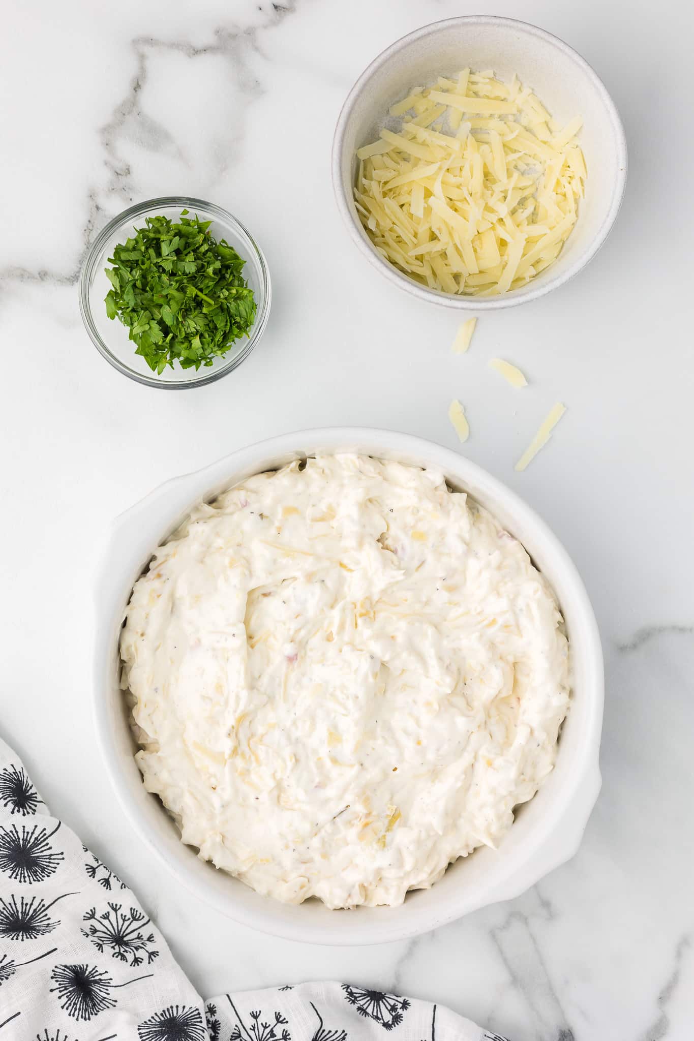 All the ingredients mixed and placed into a baking dish for hot artichoke dip.