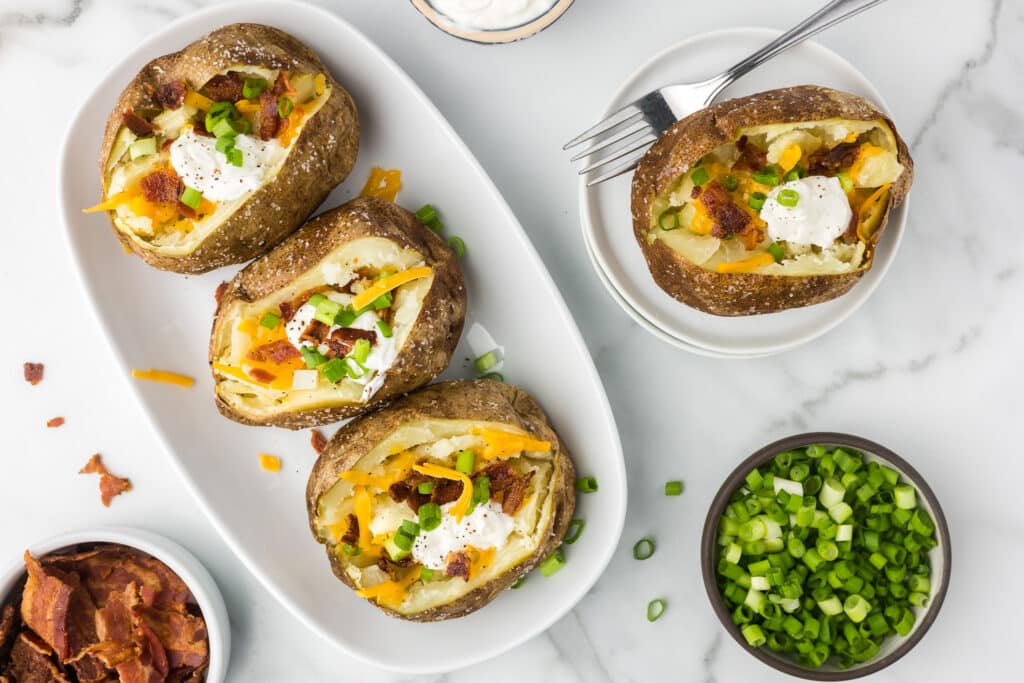 Air Fryer Loaded Potatoes on a dish with toppings.