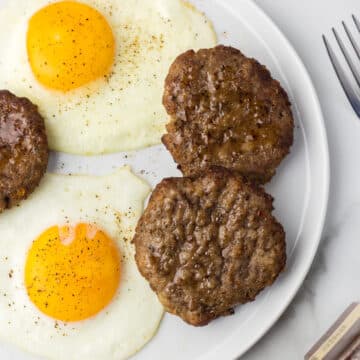 Air Fryer Breakfast Sausage on a plate with eggs.