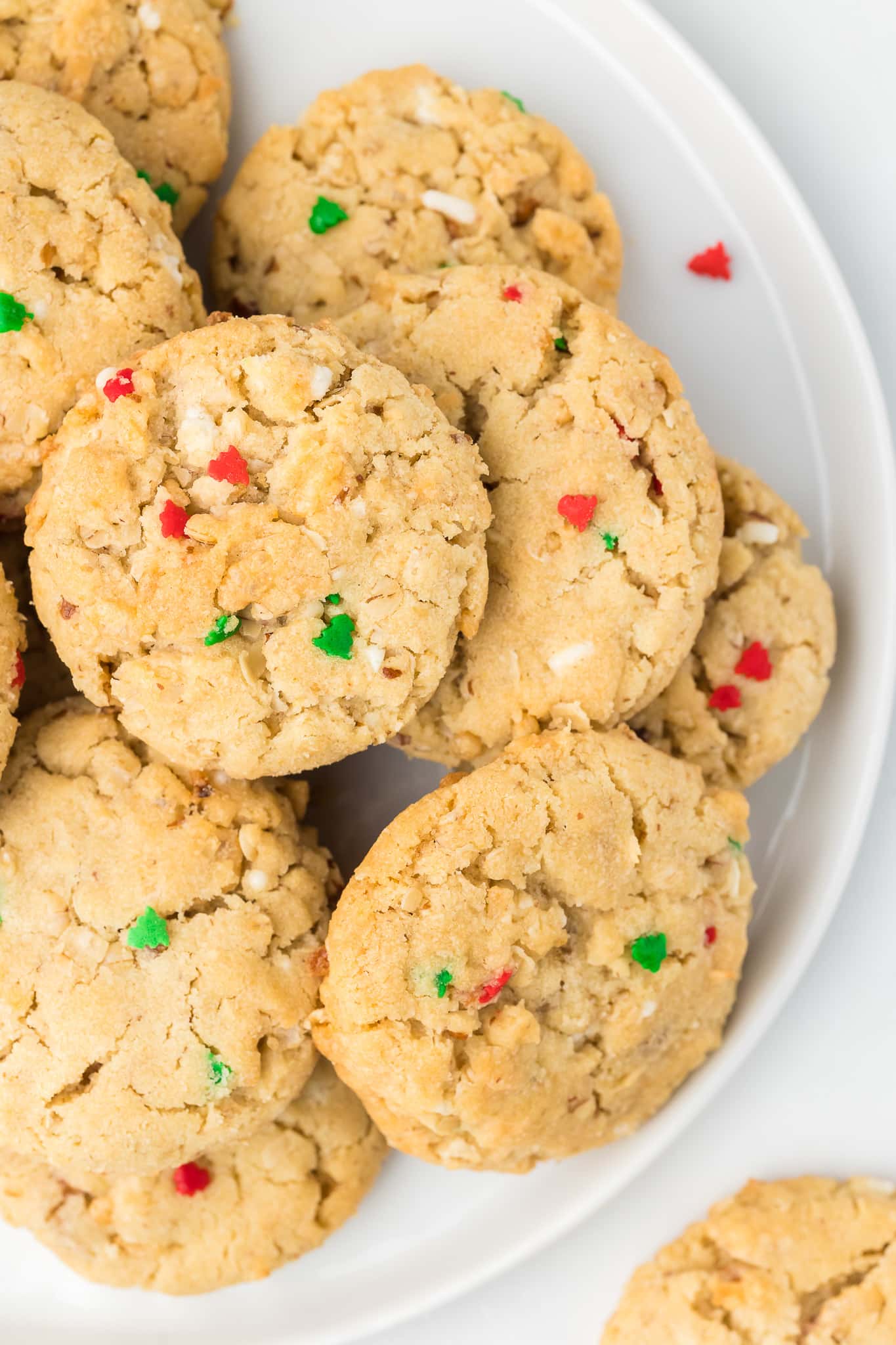 Everything cookies on a white plate with christmas tree sprinkles.