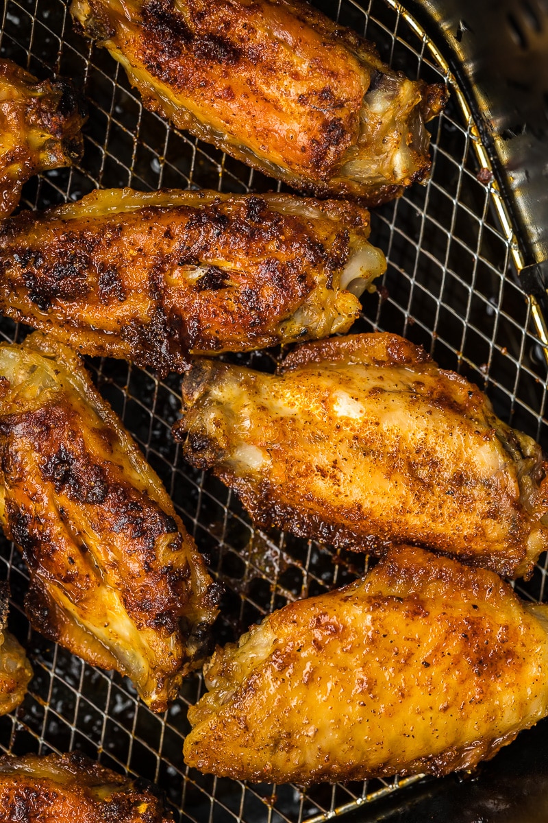 Chicken wings in an air fryer basket after rewarming.