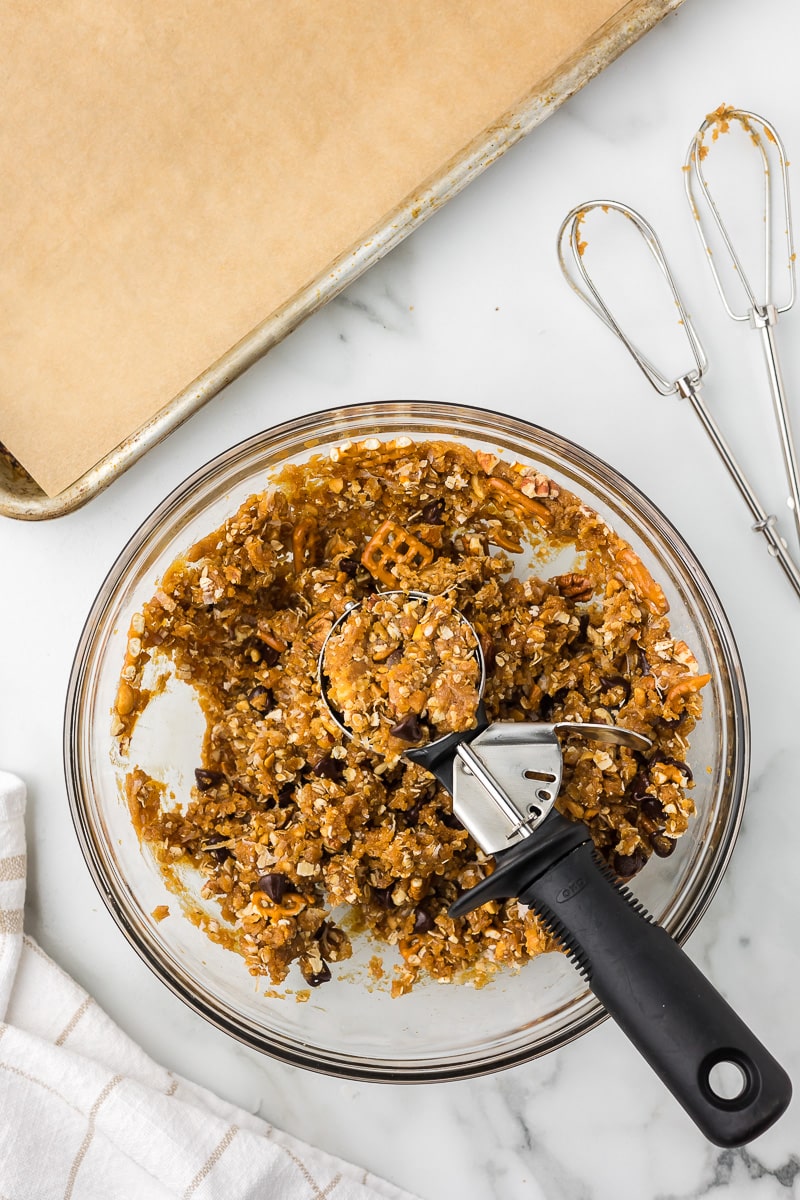 Cookie dough in a bowl with a cookie scoop.