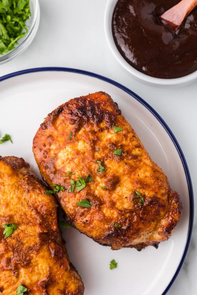 Air Fryer BBQ Pork Chops with bbq sauce and fresh parsley.