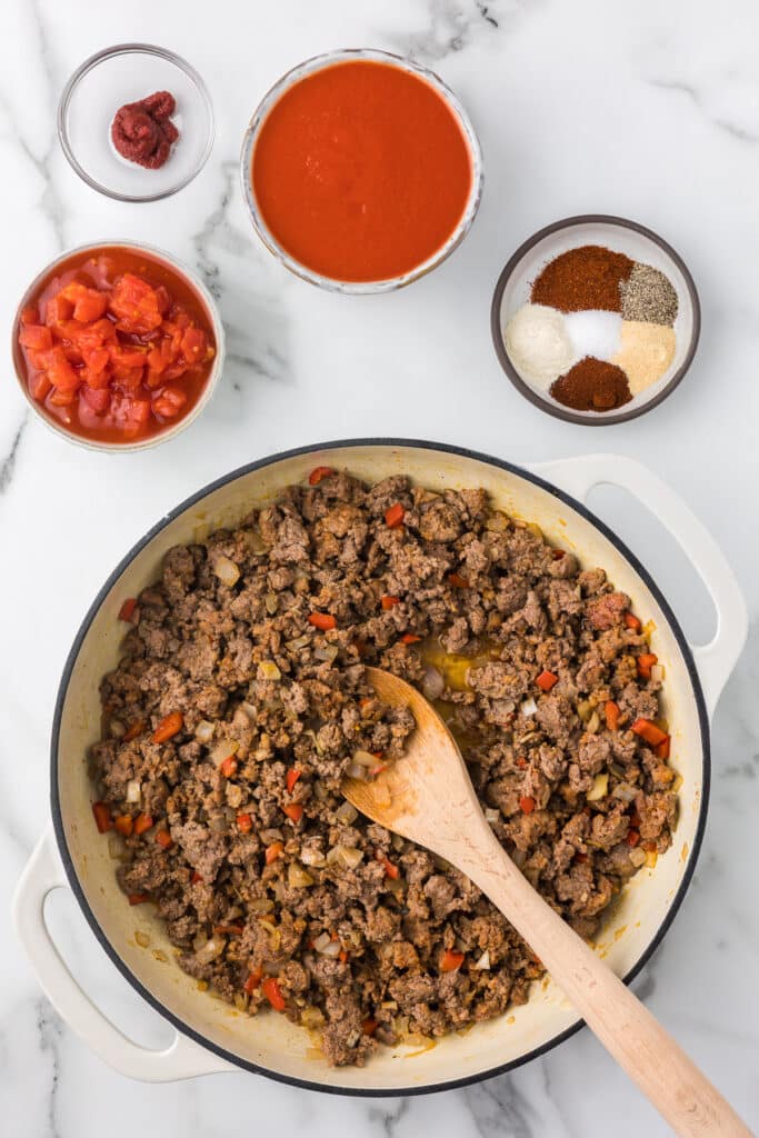 Chorizo and ground beef with peppers and onion in a pan.